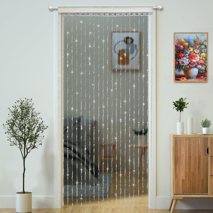 a living room with a sliding glass door that has silver stars on it and white curtains