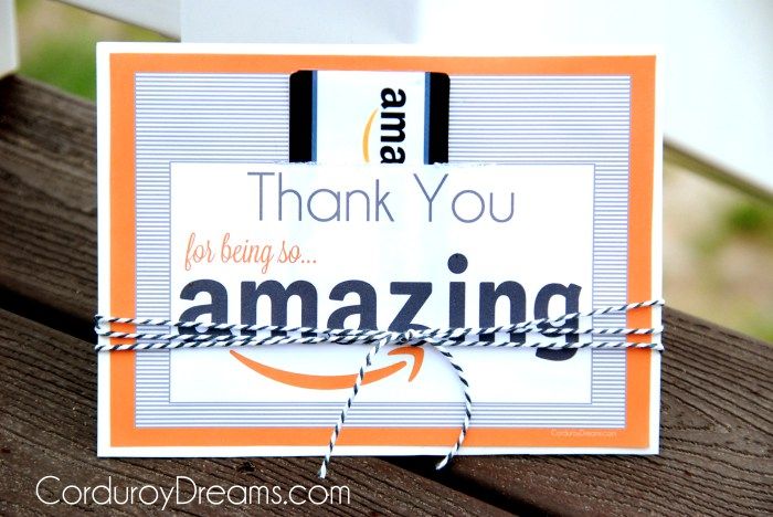 an orange and white thank you card sitting on top of a wooden table