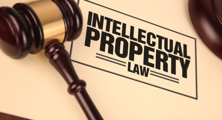 a judge's gavel next to a sign that reads, intellectional property law