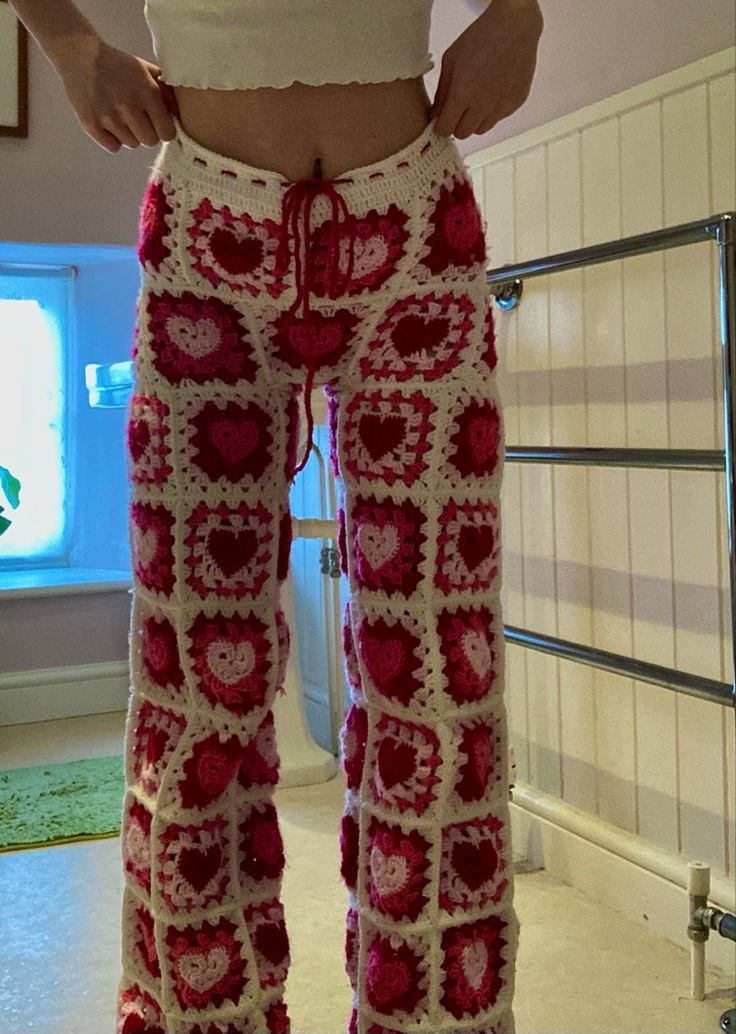 a woman is wearing crocheted pants with hearts on them