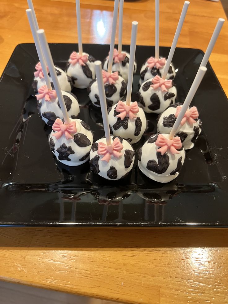 there are some cake pops with pink bows on them and white sticks sticking out of them