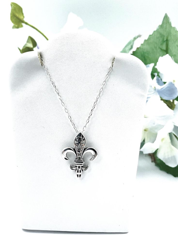 ntroducing our exquisite 925 sterling silver Fleur de Lis pendant necklace, a timeless symbol of elegance and sophistication. This pendant is expertly crafted and stamped with the 925 hallmark, ensuring its authenticity and superior quality. The pendant measures approximately 0.93 inches in width and 1.22 inches in length, making it a perfect statement piece without being overly large. For your convenience, this pendant is available with an optional 18-inch sterling silver cable link chain, allowing you to customize your look to suit your style. This necklace not only enhances your jewelry collection but also makes a thoughtful gift for someone special. Embrace the classic beauty of the Fleur de Lis with this stunning sterling silver pendant necklace. Satisfaction Guaranteed! Classic Sterling Silver Charm Necklace For Anniversary, Classic Sterling Silver Necklace For Memorial, Classic Hallmarked Charm Necklaces For Anniversary, Elegant Silver Charm Necklaces For Memorials, Elegant Silver Charm Necklaces For Memorial, Elegant Silver Charm Necklace For Memorials, Classic 925 Stamped Necklace As Gift, Classic 925 Stamped Necklaces For Gift, Classic Silver Jewelry With Hallmark