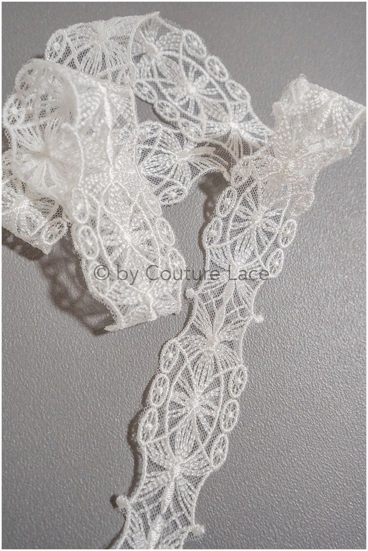 two pieces of white lace on a gray background