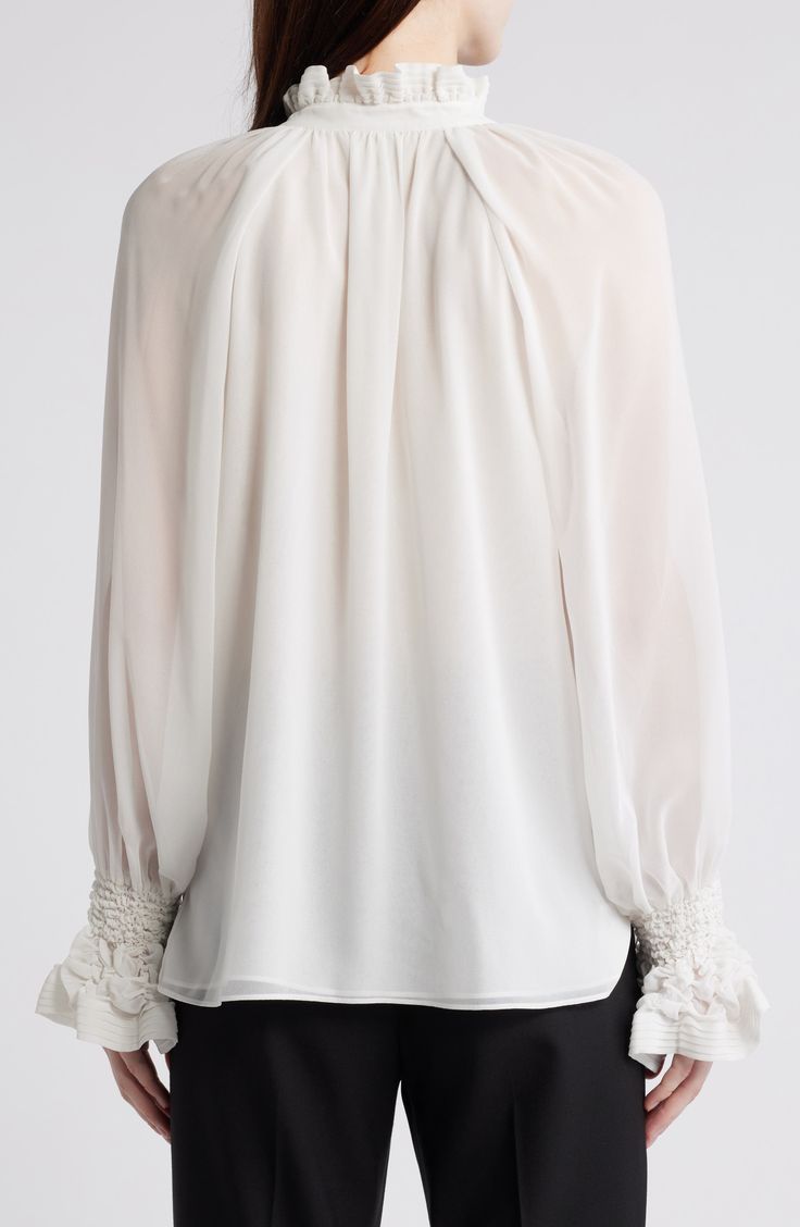 Cut from frothy chiffon and refined with shirred details, this graceful top will be worn from work days to evenings out. 26 1/2" length High neck Long sleeves 100% polyester Dry clean Imported Chiffon Blouse With Blouson Sleeves, Chic Flowy Blouse With Smocked Bodice, Elegant Chiffon Blouse With Ruffles, Flowy Elegant Tops, Chic Chiffon Tops For Wedding, White Chiffon Top For Wedding, Elegant Chiffon Blouse, Elegant Evening Chiffon Tops, Elegant Tops With Smocked Bodice For Spring