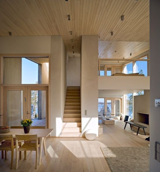 a living room filled with lots of furniture next to a wooden floor covered in windows