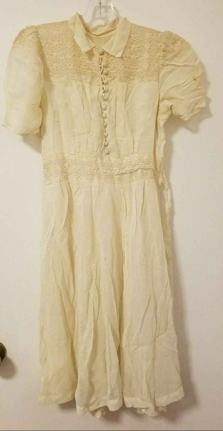 Romantic 1920s style Gatsby style dress  Vintage Cream / Ivory Lace DRESS 12 Covered buttons cascade the front bodice creating extra perfect detail. Lots of intricate design details, flared skirt,  lace inserts and embroidery in front. Built-in slip liner Side hooks and back ties This dress does not have tags.  I would consider it a size small.  Approximate sizing:  Armpit to armpit: 28"; Armpit to hem: 31"; Waist 28"; NOTE:  This dress is an ivory / cream color.  Some photos make it appear dark Gatsby Style Dresses, Lace Panel Dress, Cream Color Dress, Ivory Lace Dress, 1920s Style, Gatsby Style, Color Dresses, Lace Vintage, Tailored Dress