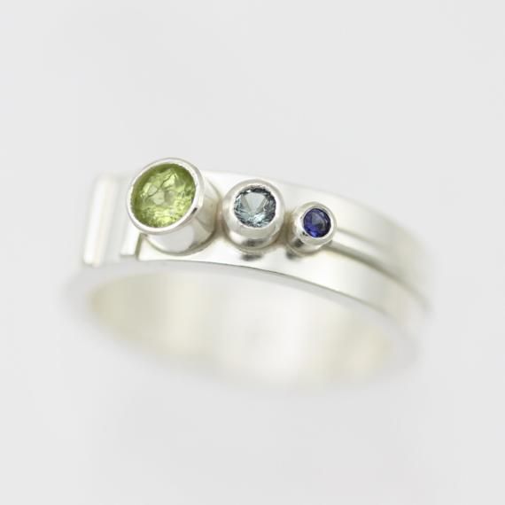 3 Stone Sequence Mother's Ring in sterling silver Modern Peridot Rings For Anniversary, Modern Multi-stone Birthstone Ring For Promise, Modern Multi-stone Birthstone Ring For Anniversary, Modern Multi-stone Sapphire Anniversary Ring, Stackable Peridot Birthstone Ring For Anniversary, Modern White Gold Birthstone Ring With Accent Stones, Modern Sterling Silver Birthstone Ring For Promise, Modern Sterling Silver Stackable Rings With Tension Setting, Promise Birthstone Ring With Tension Setting In Sterling Silver