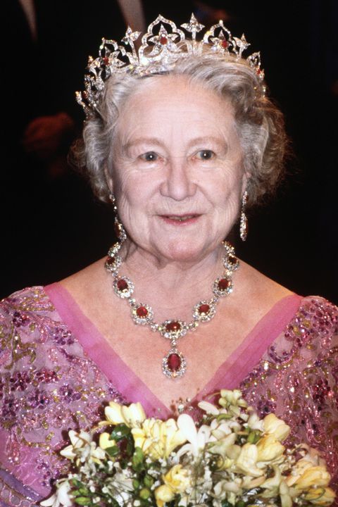 an older woman wearing a tiara and holding flowers