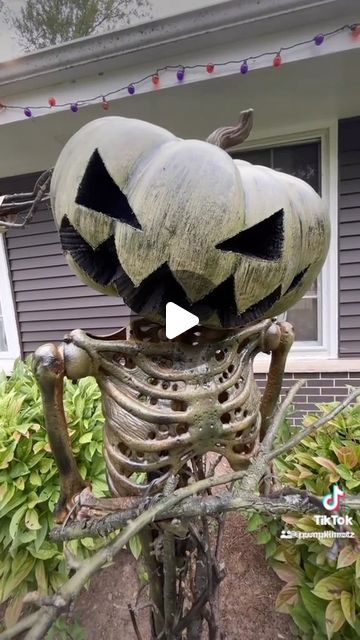 a skeleton statue with two pumpkins on it's head