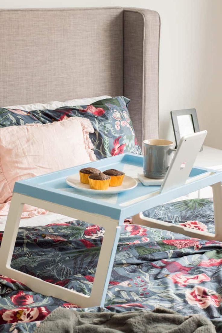 a bed with a laptop and cupcakes on it