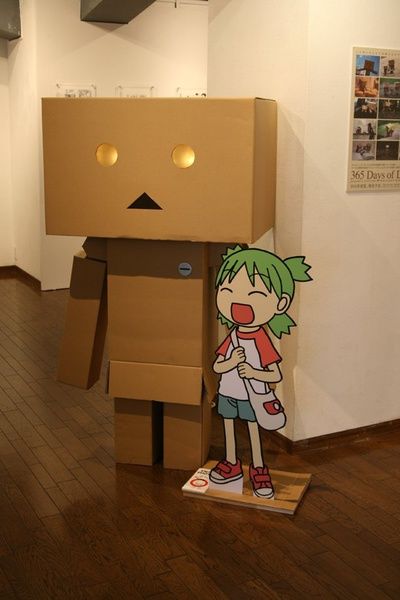 a cardboard robot standing on top of a wooden floor