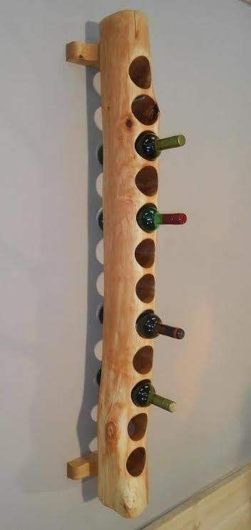 a wine rack made out of wood with six bottles in it and several empty ones on the wall