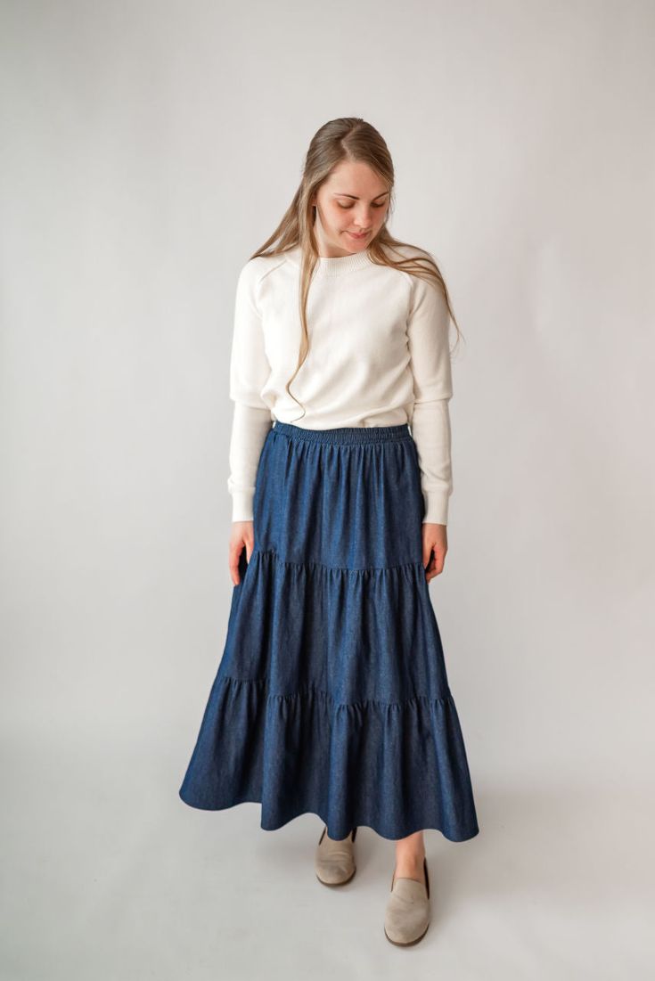 Perfect for a spring picnic or an everyday morning, the 'Celeste' skirt is so lovely and versatile! Constructed from lightweight cotton denim for a comfortable fit that moves with you, this skirt features hidden side pockets and an elastic waistband. Falling in ankle-length tiers, this comfortable skirt will compliment any simple top. Fit: true to size! Style: functioning pockets, elastic waist, tiered Color: dark wash Fabric content: 100% cotton Care instructions: wash gentle cycle, cold; lay f Spring Picnic, Comfortable Skirts, Be Intentional, Simple Top, Modest Clothing, Garment Labels, Curated Gifts, Tier Skirt, Tiered Skirt