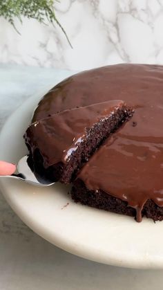 a piece of chocolate cake on a white plate with a large knife in the middle