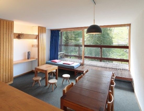 a living room filled with furniture next to a large window covered in blue drapes