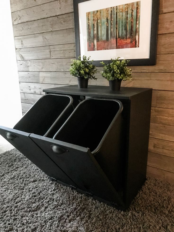 a black cabinet with two planters on top