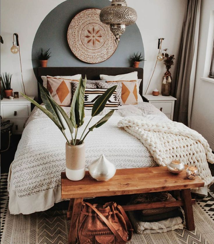 a bed room with a neatly made bed and a plant