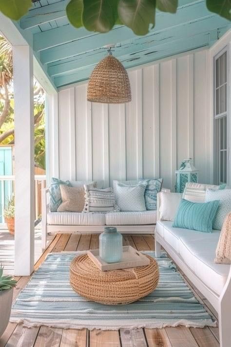 a porch with white furniture and blue accents