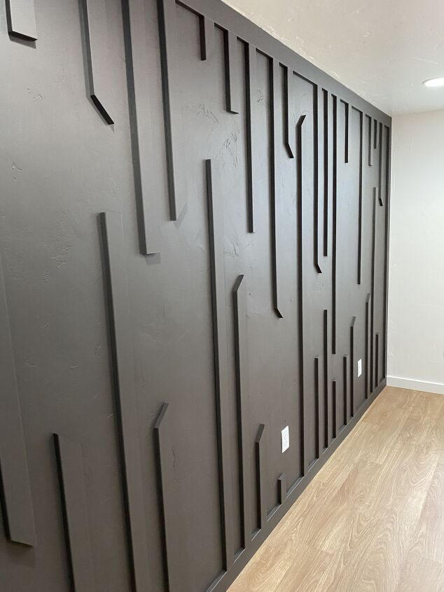 a room with wood floors and black wall panels on the walls, along with wooden flooring