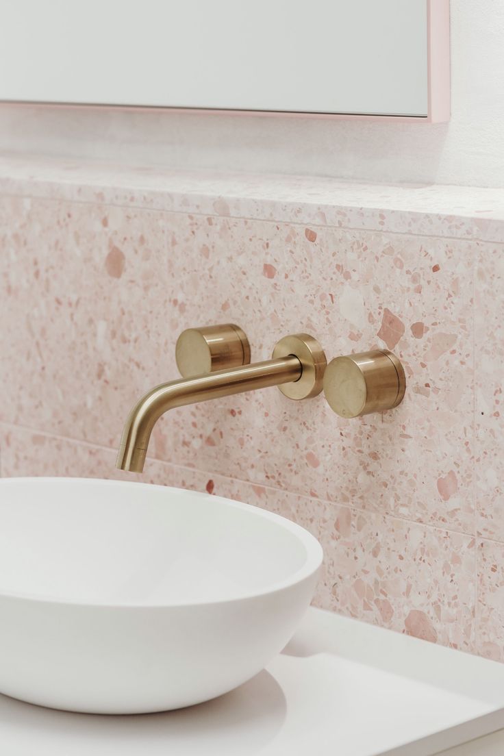 a white bowl sitting on top of a counter next to a faucet