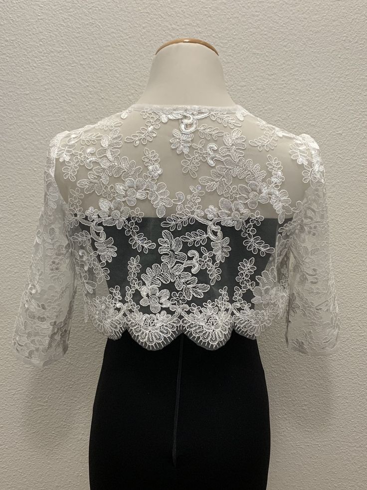 White floral lace wedding handmade bolero. Bridal and evening lace long sleeves jacket. Scalloped edgings and sleeves shrug. Corded Sequined Lace Bolero.    This elegant handmade design has a pretty scalloped lace edge all the way around and on the long-length sleeves as well. A small hook closure finishes it off at the neckline to allow movement and to show your dress or top underneath. The hand-made pearl brooch covering the hook closure gives a more luxurious and stylish look.  Sizes  S - M Lace Mother Of The Bride Dress With Long Sleeves, Fitted Long Sleeve Lace Mother Of The Bride Dress, Long-sleeve Lace Mother Of The Bride Dress, Long-sleeved Lace Mother Of The Bride Dress, Fitted Lace Long Sleeve Mother Of The Bride Dress, Mother Of The Bride Long Sleeve Lace Dress, Elegant Lace Bodice For Ceremony, Elegant Lace For Ceremony, Party Shrug With Lace Trim