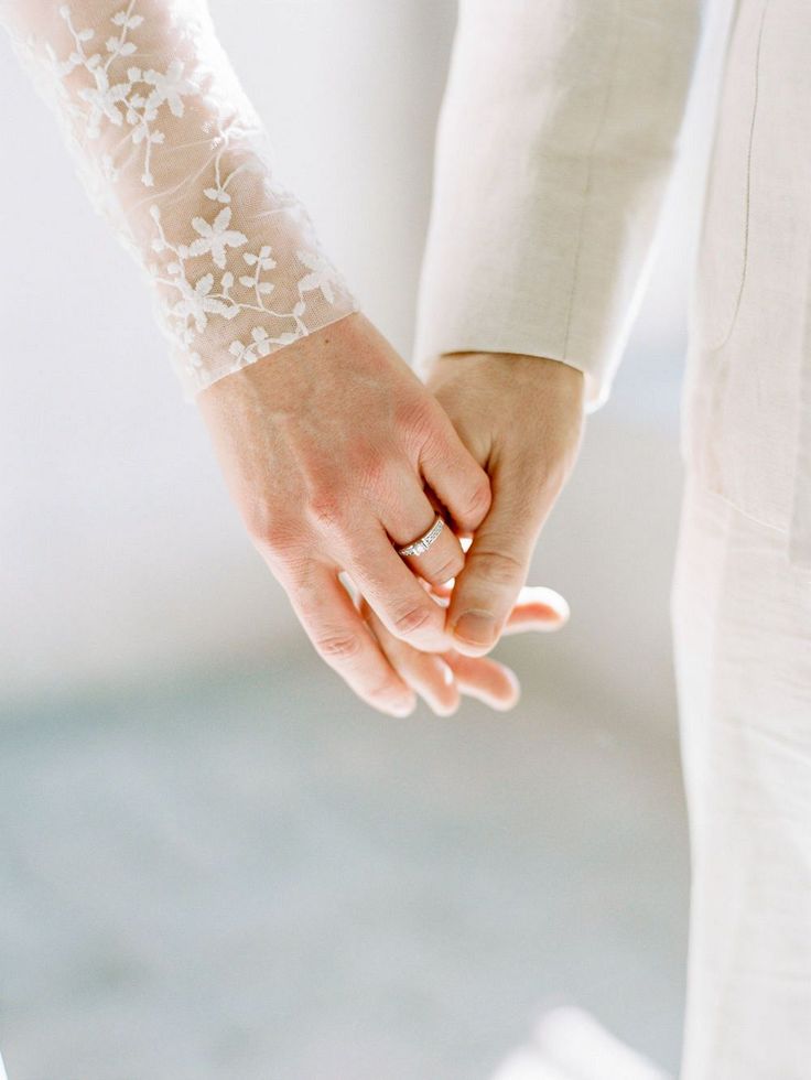 the bride and groom are holding hands