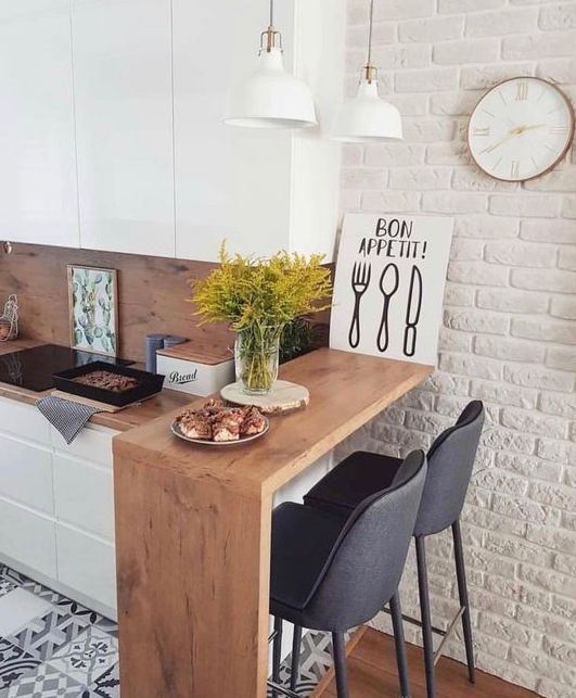 a kitchen with white brick walls and black chairs