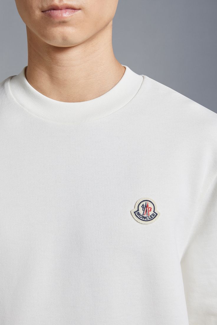 A casual staple, this sweatshirt is crafted from pure cotton. The classic crew neck style for men is embellished with a felt logo patch on the chest, a distinct Moncler design code. White Crew Neck T-shirt With Ribbed Collar, White Crew Neck Sweatshirt With Logo, Classic Cotton Sweatshirt With Logo, Casual Crew Neck Sweatshirt With Appliqué Logo, Casual Sweatshirt With Appliqué Logo For Streetwear, Casual Crew Neck Sweatshirt With Logo Patch, Streetwear Crew Neck Sweatshirt With Logo Patch, White Logo Patch Sweatshirt For Streetwear, White Cotton Sweatshirt With Logo Patch