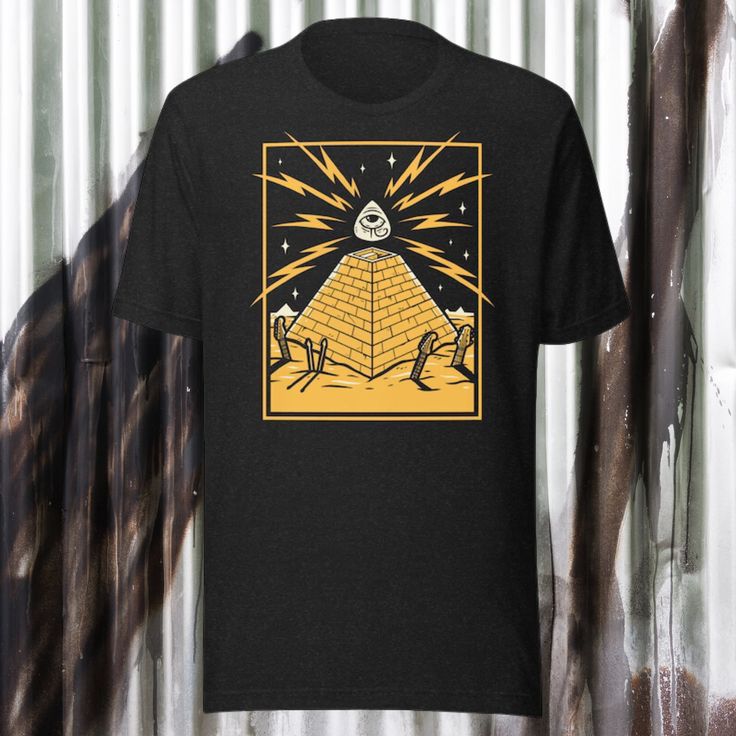 Step into a world of retro futuristic mystique with our Pyramid Eye shirt (yellow edition). This captivating design features a retro futuristic pyramid with an eye in the center, set against a backdrop of gold and black ruins. The eye is electrified with lightning in the background, adding a touch of intrigue and power to the design.  With its fusion of retro futuristic, rock music vibes, and buried instruments in the sand, this shirt is a visual feast that will transport you to another era. Made with premium materials, our shirt offers both comfort and style. Embrace the enigmatic allure of retro futurism and make a statement wherever you go with our Pyramid Eye shirt. * 100% combed and ring-spun cotton (Heather colors contain polyester) * Fabric weight: 4.2 oz/yd² (142 g/m²) * Pre-shrunk Yellow Band Merch T-shirt With Graphic Design, Eye Shirt, Pyramid Eye, Retro Futuristic, Original Music, Rock Shirts, Gift For Music Lover, Retro Music, Retro Futurism