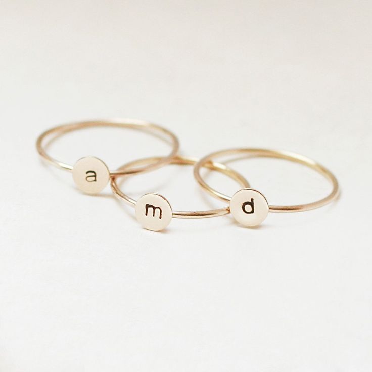 One gold letter ring. Personalize a gift she'll treasure with our gold initial ring. An adorably petite initial, imprinted on a 14k gold filled disk - paired with a super skinny (1mm) gold filled band - creates the perfect stacking ring, customized with your monogram. Lovely as a stand alone. Also sits beautifully with multiple initials stacked or our hammered gold stacking ring bands. This gold initial ring arrives custom made to order in your size hand stamped with the letter of your choice. A Gold Stackable Rings With Initials For Everyday, Everyday Gold Stackable Rings With Initials, Everyday Stackable Yellow Gold Rings With Initials, Personalized Yellow Gold Initial Ring For Everyday, Everyday Personalized Yellow Gold Initial Ring, Dainty Gold Stackable Rings With Initials, 14k Gold Stackable Rings With Initials, Simple Gold Stackable Initial Ring, Dainty 14k Gold Stackable Initial Ring