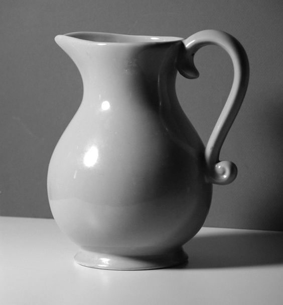 a white vase sitting on top of a table