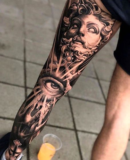 a man with a tattoo on his arm is holding a drink in front of him