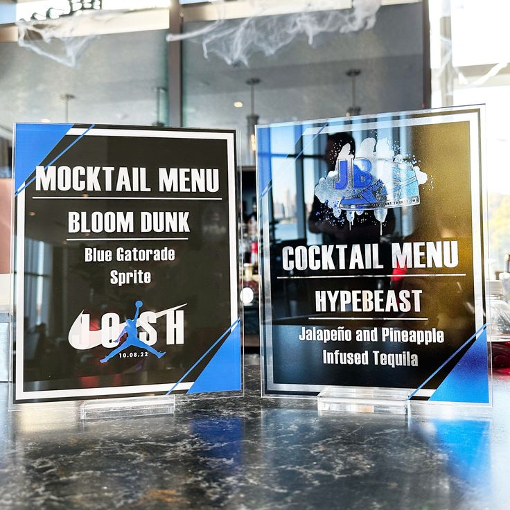 two menus sitting on top of a table in front of a window with frosted glass