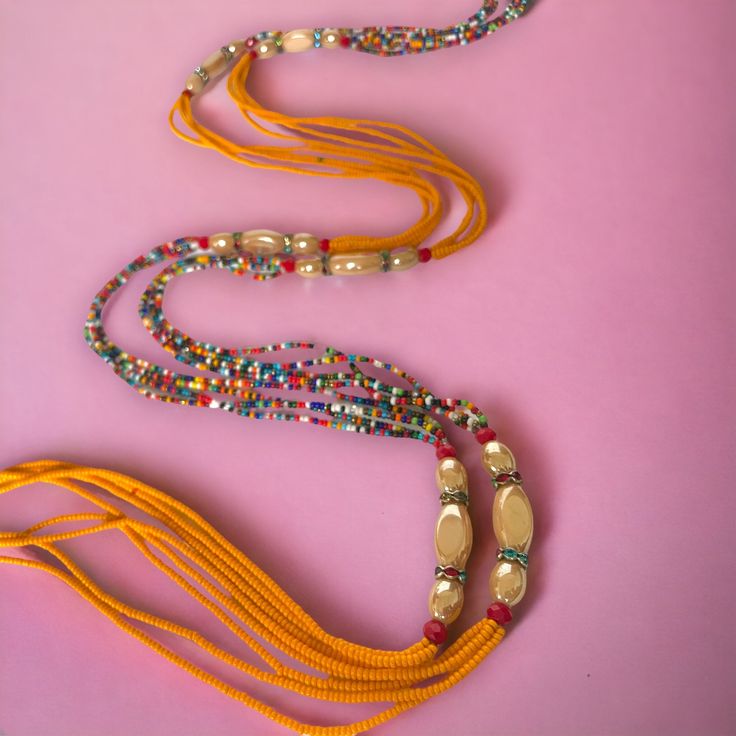 **DRIP FAIRY IS CURRENTLY OPEN FOR PRE-ORDERS ONLY! ALL ORDERS WILL NOT BE SHIPPED OUT UNTIL FEBRUARY 24, 2024. AS A THANK YOU TO THOSE PRE-ORDERING THESE ORDERS WILL ALSO INCLUDE A FREE GIFT! This handmade Ivorian waist bead has an incredibly beautiful four strand design in the colors of purple, gold, and red. Each waist bead is carefully crafted using a combination of strong threads woven together to create a durable and long-lasting piece. The beads themselves are made from glass and each one is carefully chosen to ensure a consistent look and feel to the waist bead. Crafted using high-quality materials, this waist bead is durable and designed to last. The strands provide a comfortable and secure fit, while the adjustable length ensures that it can fit a wide range of waist sizes. The p Multi-strand Beaded Waist Beads For Festival, Spiritual Beaded Waist Beads For Beach, Traditional Beads For Beach Festivals, Traditional Long Necklace Beads For Festival, Multi-strand Beaded Bracelets With Large Beads For Festivals, Adjustable Beaded Bracelets For Rituals, Multicolor Beaded Chain Waist Beads For Festivals, Adjustable Beaded Necklaces For Rituals, Adjustable Beaded Waist Beads For Festivals