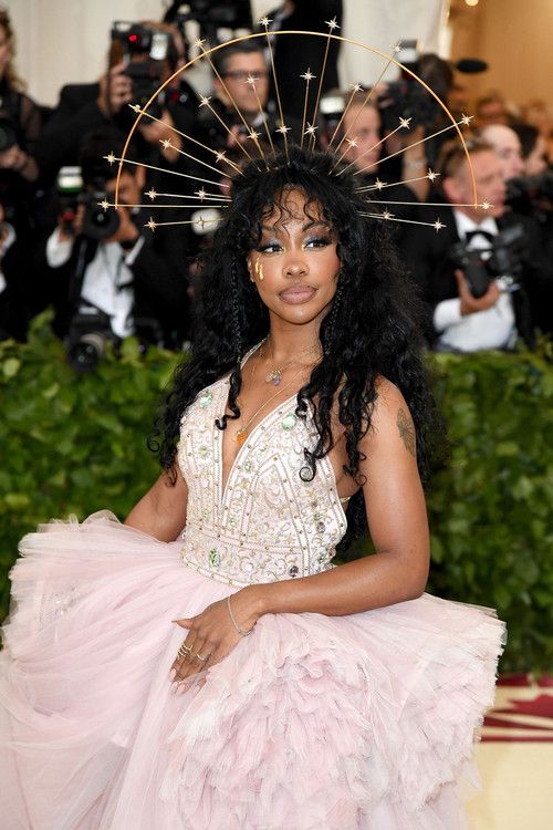 a woman in a pink dress with an elaborate headpiece