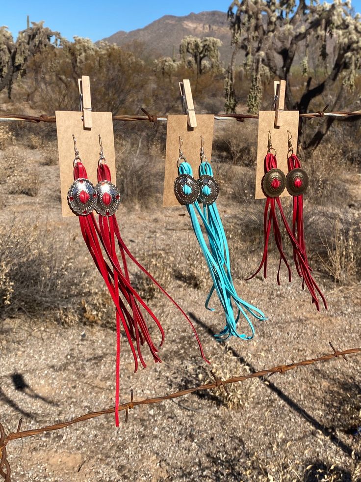 These beautiful concho earrings are a great statement piece. No other jewelry needed they measure about 12 ones long Are made from deerskin lace Have Swarovski crystal detailing And hypo allergenic hooks Available in 3 colors. Red. Turquoise and mustard yellow and either silver or bronze concho Southwestern Tassel Earrings For Festivals, Southwestern Fringe Earrings For Festivals, Southwestern Fringe Dangle Earrings, Adjustable Concho Earrings For Festival, Southwestern Fringe Dangle Jewelry, Bohemian Concho Earrings For Festival, Southwestern Tassel Earrings, Cowgirl Fringe, Concho Earrings