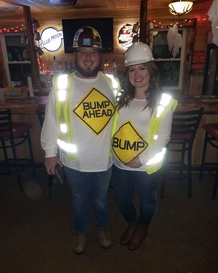 two people wearing safety vests and hard hats pose for a photo in a restaurant