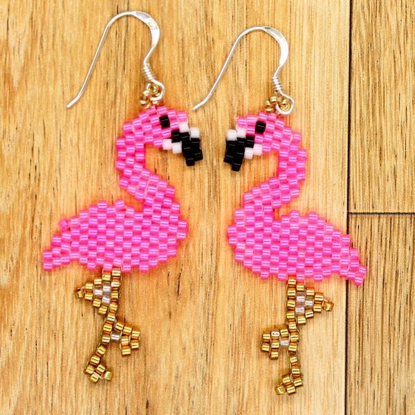 pink flamingo beaded earrings on wooden floor