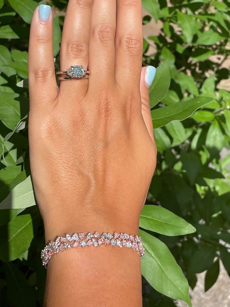 a woman's hand with a ring on it and a bracelet around her wrist