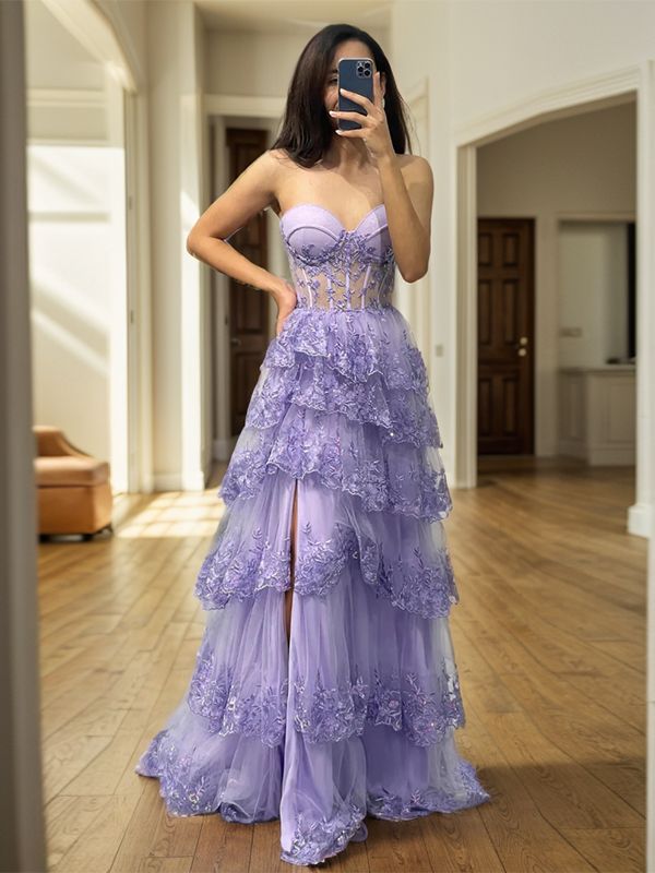 a woman in a purple dress taking a selfie with her cell phone while standing on a wooden floor