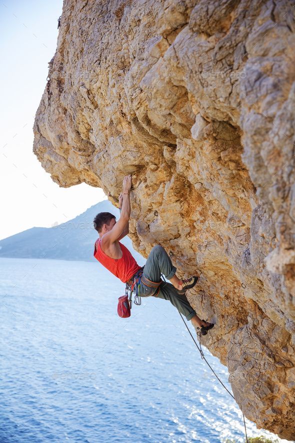 a man climbing up the side of a cliff