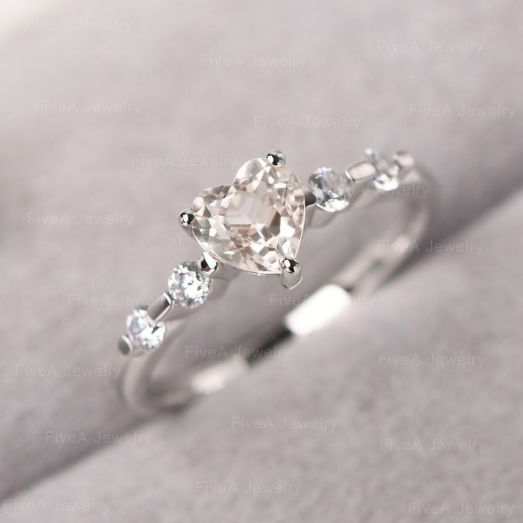 a diamond ring with three stones on it's side, sitting on a white cloth