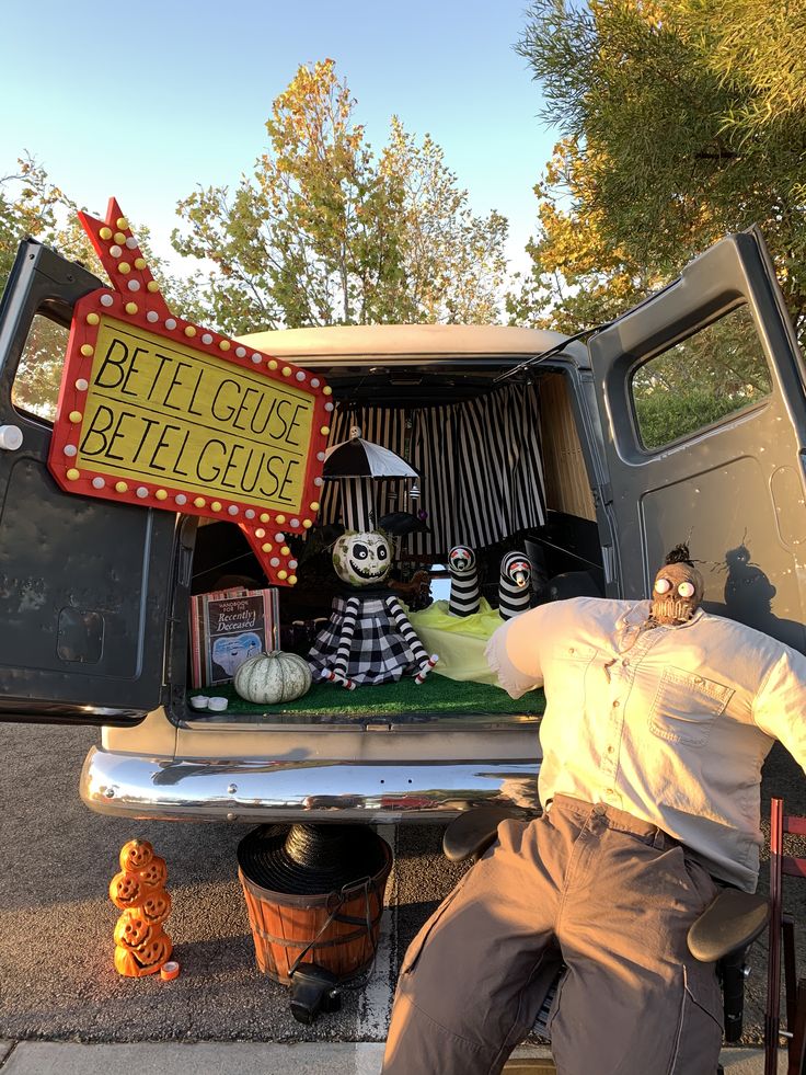 a man sitting in the back of a pick up truck with halloween decorations on it