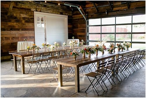 a long table with chairs and flowers on it