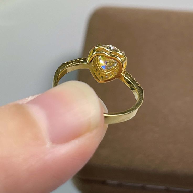 a person is holding a ring with a diamond in it's center and gold band