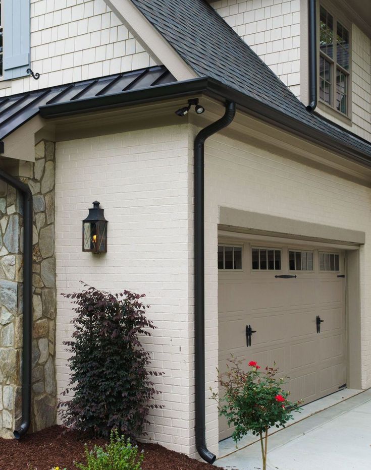 a white brick house with two garage doors