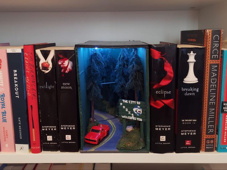 a book shelf filled with lots of books on top of each other and a red car in the middle