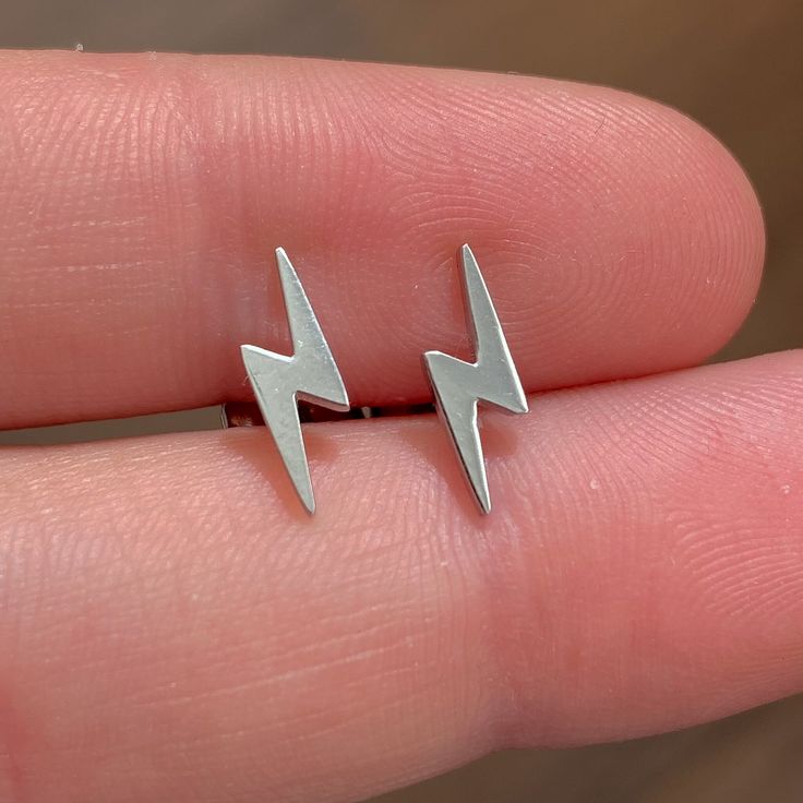 These Lightning Bolt Earrings are made out of high quality stainless steel which makes them water proof and tarnish free. The color doesn't fade or rust over time. The size is adjustable. Our waterproof jewels are perfect to wear every day and everywhere. These small stud earrings have a minimalist style and look very elegant. You can choose between gold earrings or silver earrings, and between a single earring or a pair, at the checkout. *Handmade item. *Waterproof Color: WATERPROOF. *Tarnish f Piercing Labret, Bolt Earrings, Minimalist Earrings Gold, Lightning Bolt Earrings, Labret Studs, Small Earrings Studs, Earrings Small, Style Minimaliste, Earrings Minimalist