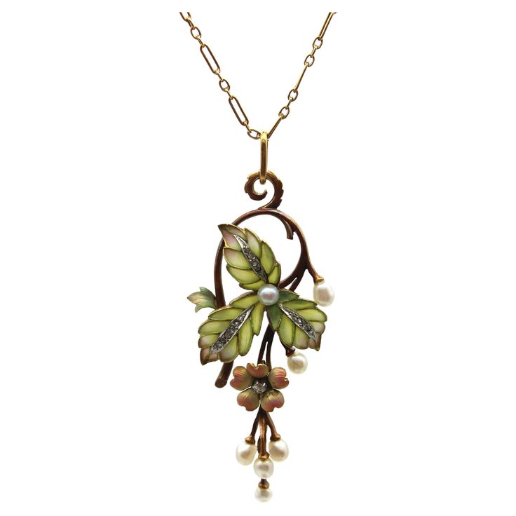 A classic Art Nouveau design, this 15k rose gold necklace features stunning plique-à-jour, Rose Cut diamonds, and beautiful pearls. The centerpiece of the necklace is articulated, hinged in two places so that the flower and pearl drops dangle freely. Three plique-à-jour leaves are translucent—the loveliest matte soft green that fades into subtle purple highlights, clearly done by a master. Each cell of the leaf is filled with plique, with a white metal (platinum or white gold) creating contrast in the center of the leaf. Inside are a channel of bead set Rose Cut diamonds. A flower is suspended from the leaves, with multi-tones of peach to pale yellow that glow against the gold, with a prong-set diamond as its piston. The design work loops over, turning the bail into a scrolling foliate. Th Designer Pendant Sets, Subtle Purple Highlights, Diamond And Pearl Necklace, Design Art Nouveau, Art Nouveau Necklaces, Bijoux Art Nouveau, Art Nouveau Pendant, Regent Street, Purple Highlights