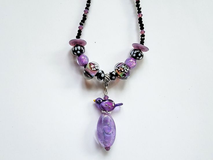 "I used beautiful lampwork beads made by Christina Burkhart, dichroic beads made by another lampwork artist and made a pendant using one of Erin Morris' bird bead. The necklace is strung with faceted black spinel beads and purple crystal beads as spacers. The necklace is 18.5\" long and the pendant is 2\". All metal components, including the lobster claw clasp is in sterling silver. As with most of my necklaces, I can add a sterling silver extension chain, if requested. Very sparkly, beautiful n Purple Beaded Necklace With Black Beads For Gift, Purple Necklace With Black Beads For Gift, Gift Purple Necklace With Black Beads, Purple Necklace With Black Beads, Butterfly Beads, Lampwork Necklace, Beautiful Neck, Bird Beads, Purple Crystal